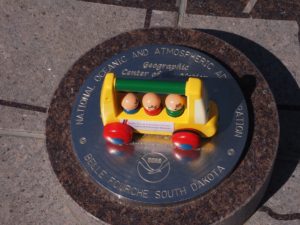 Toy bus at monument for geographic center of the USA