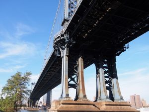 Shore-level view of Manhattan Bridge tower from underneath the span