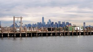 Working dock in foreground with Manhattan skyline on horizon