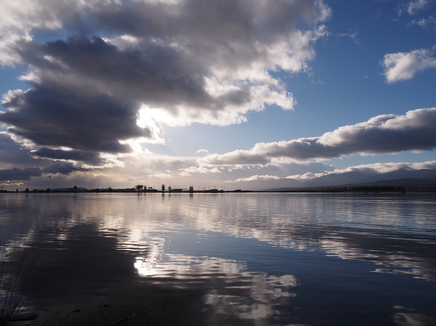 Dark and white clouds reflected in Comox Harbour in the early morning light.