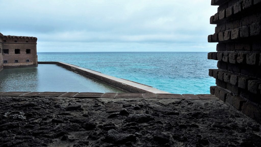 Ocean and moat view through brick arch of fort's gun deck.