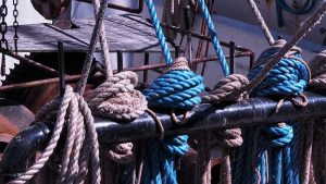 Blue and tan ropes on tied off on large black stanchion