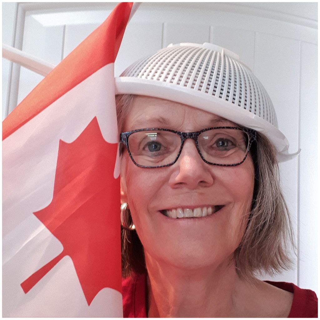 Canada Day celebrator with sieve and flag.